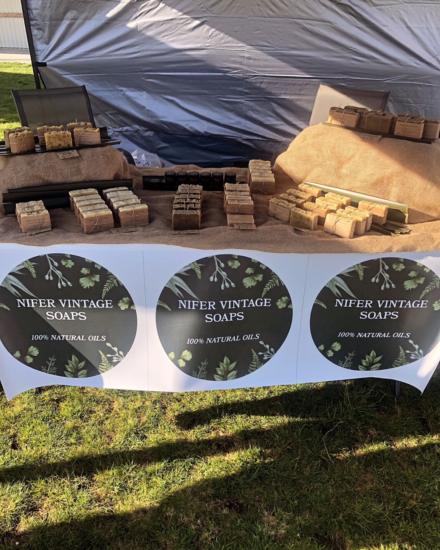 A Nifer Vintage Soaps market stall — hand-cut bars and balms arranged on hessian